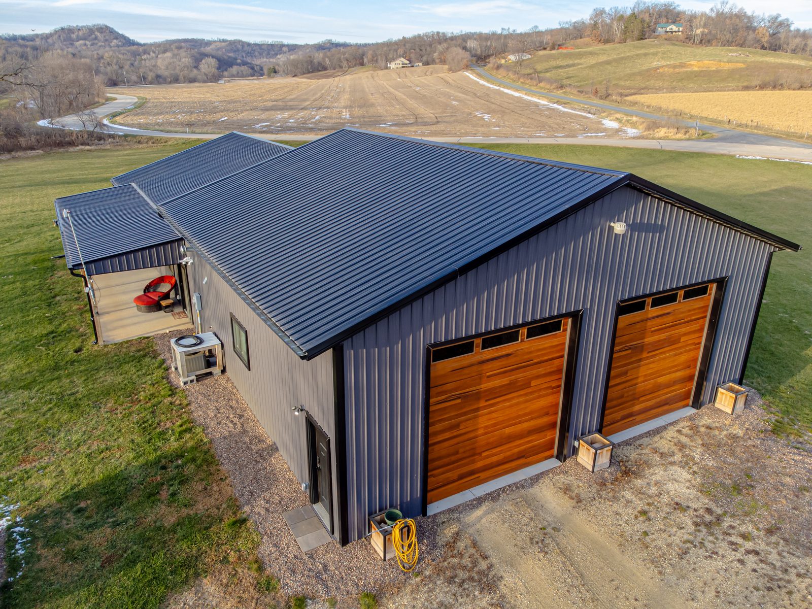 Example of a barndominium exterior with metal siding and a covered porch